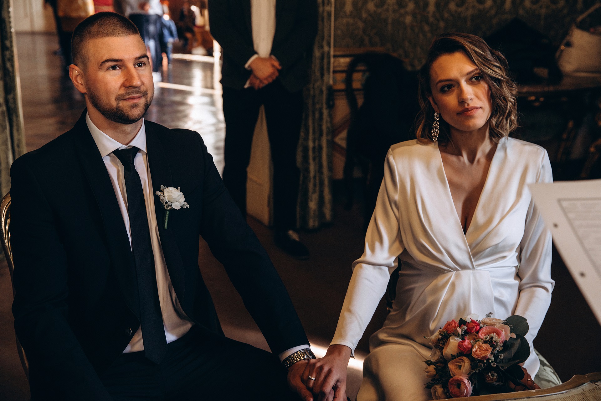 Panna Młoda w ciąży podczas ślubu w eleganckiej białej sukience na długi rękaw
