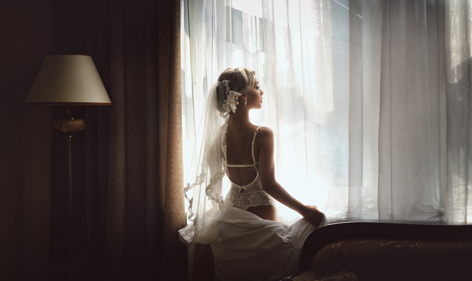 Kobieta siedząca przy łóżku, kobieta pozująca do zdjęcia w czarnym staniku, sensualna sesja zdjęciowa