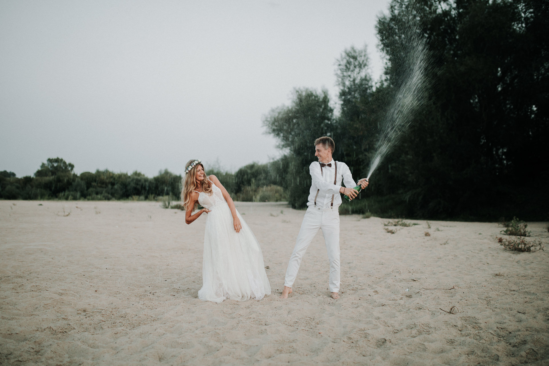 Para Młoda leżąca na kocyku na plaży podczas sesji ślubnej