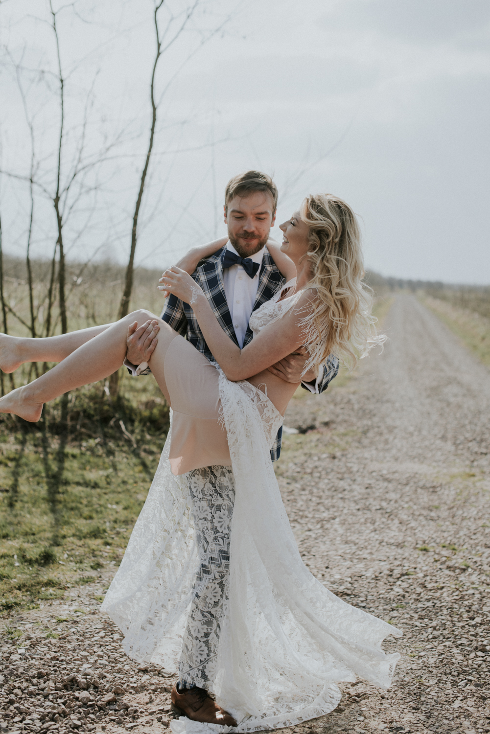Pan Młody podnosi Pannę Młodą podczas sesji boho
