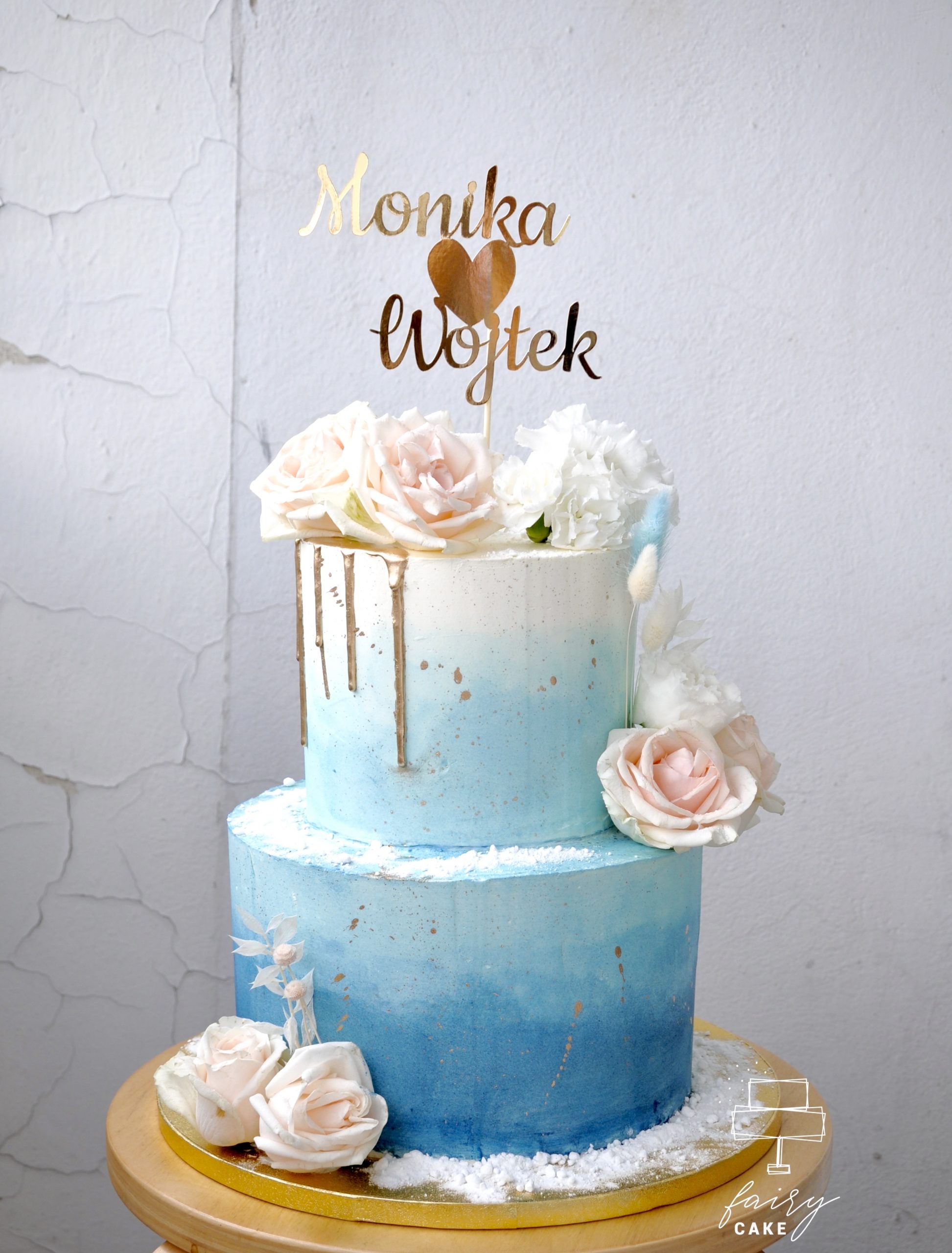 elegancki tort weselny ombre ze złotym topperem i kwiatami