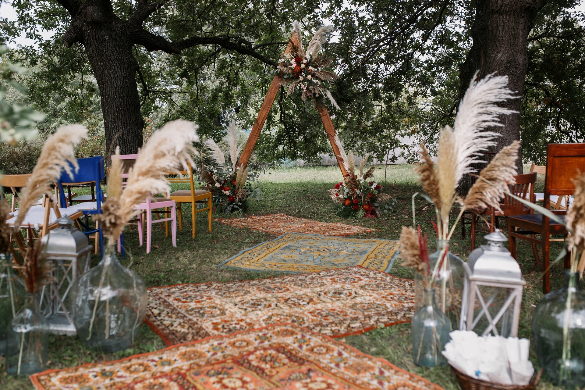 ślub plenerowy w stylu boho z drewnianymi dekoracjami i trawami pampas
