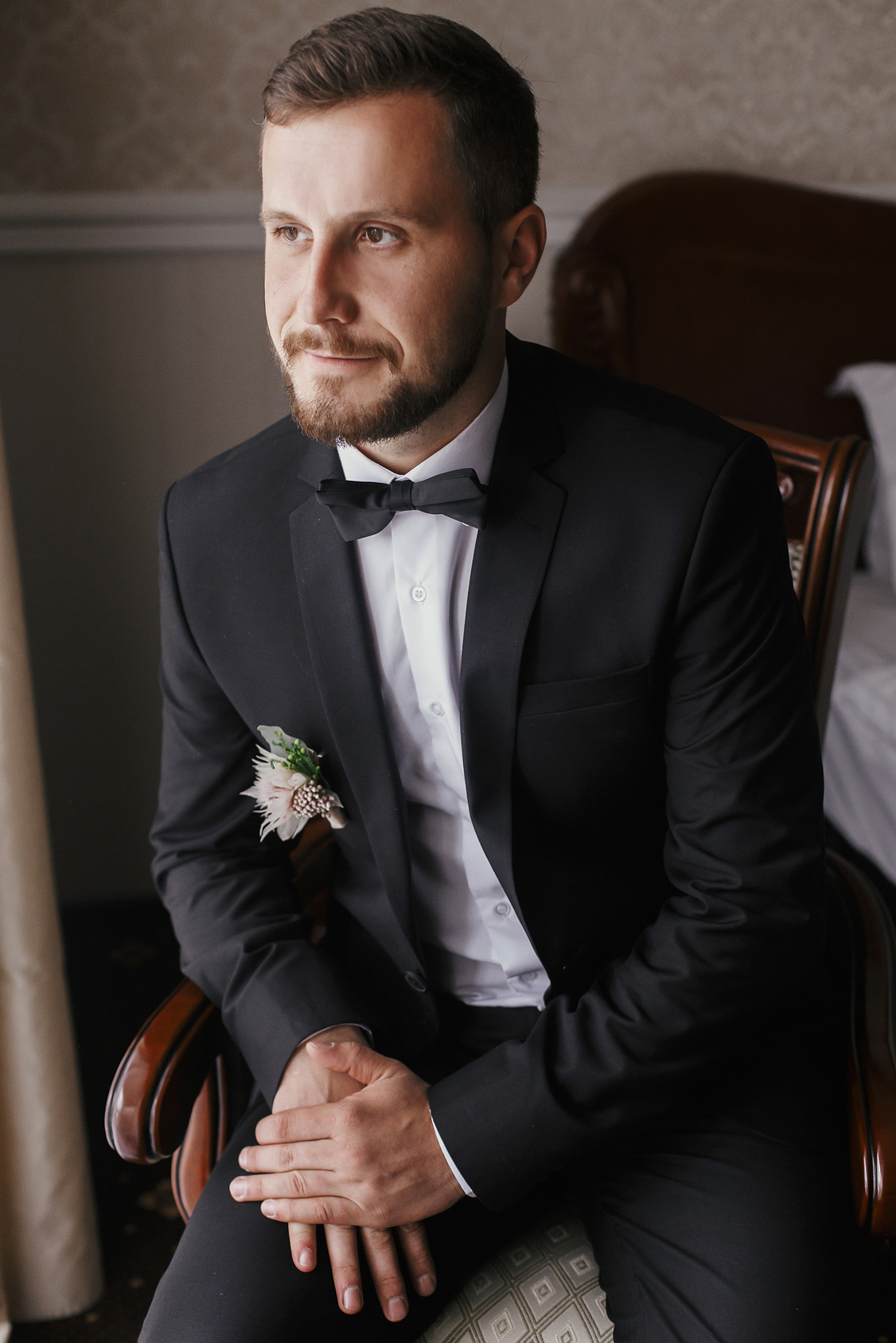 Elegancki Pan Młody w czarnym garniturze w domu
