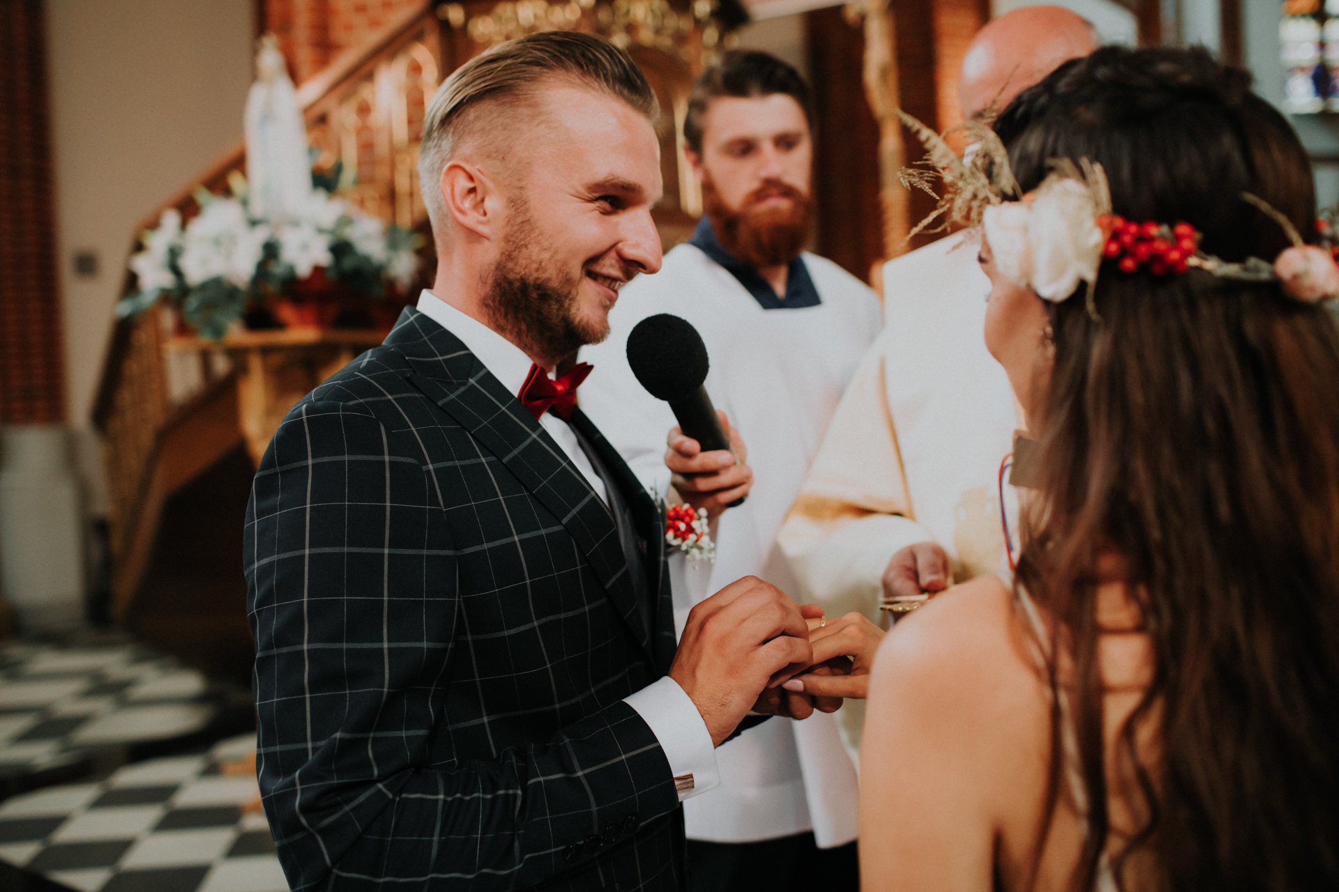 Pan Młody zaklada obrączkę Pannie Młodej podczas ślubu kościelnego