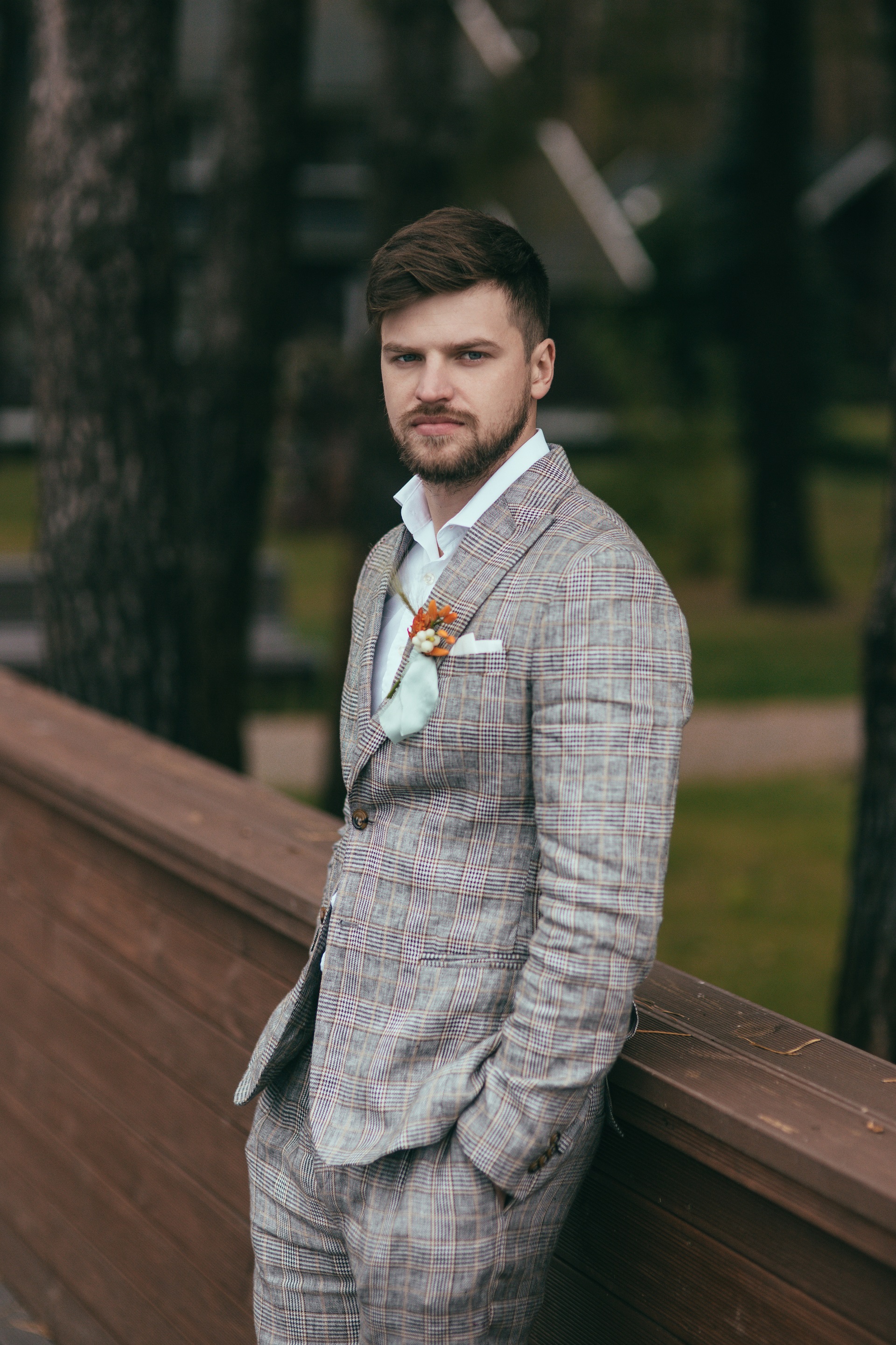 Pan Młody z brodą w stylu boho w jasnym garniturze w kratę