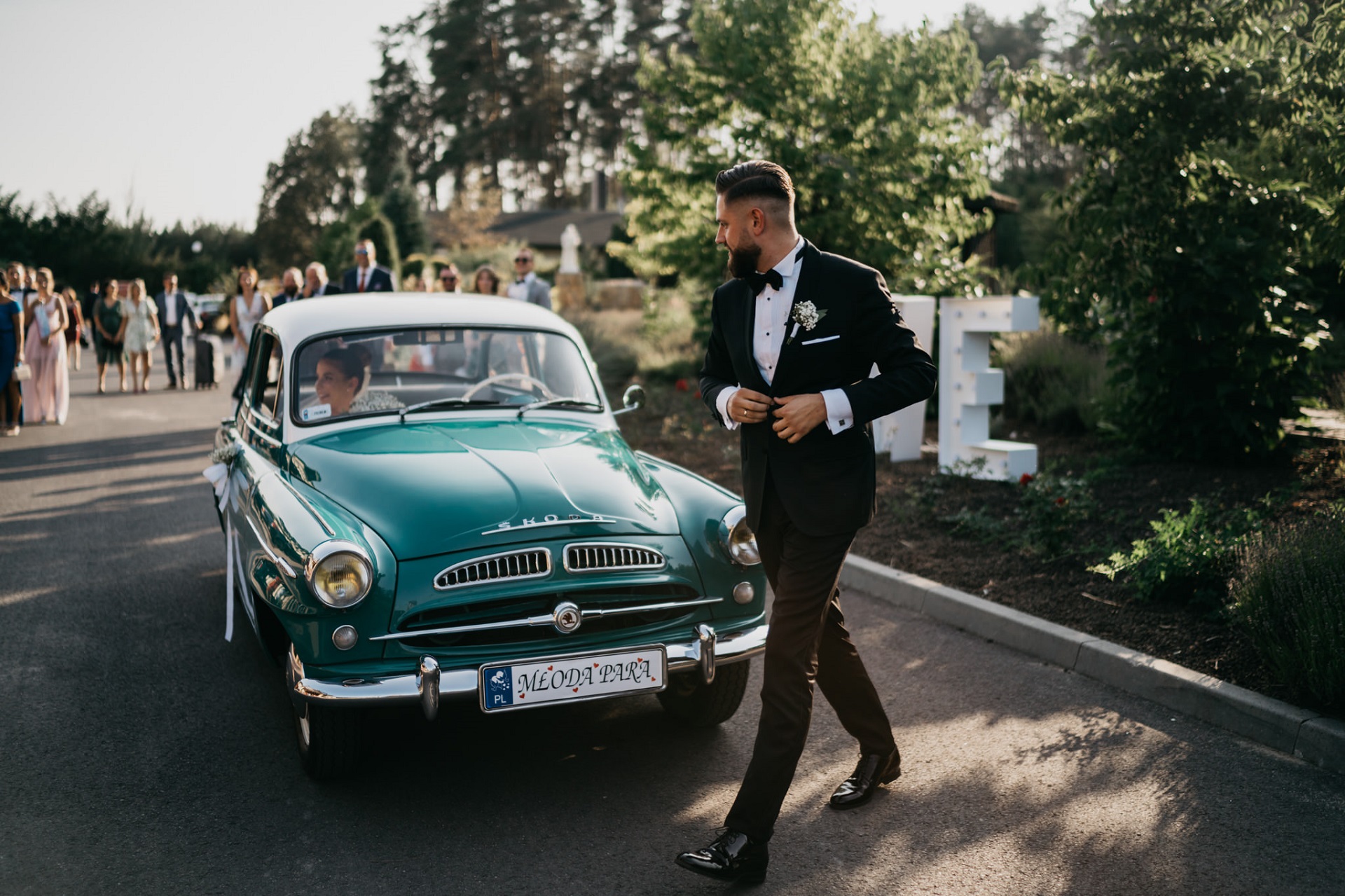 Para Młoda w samochodzie ślubnym przed salą weselną