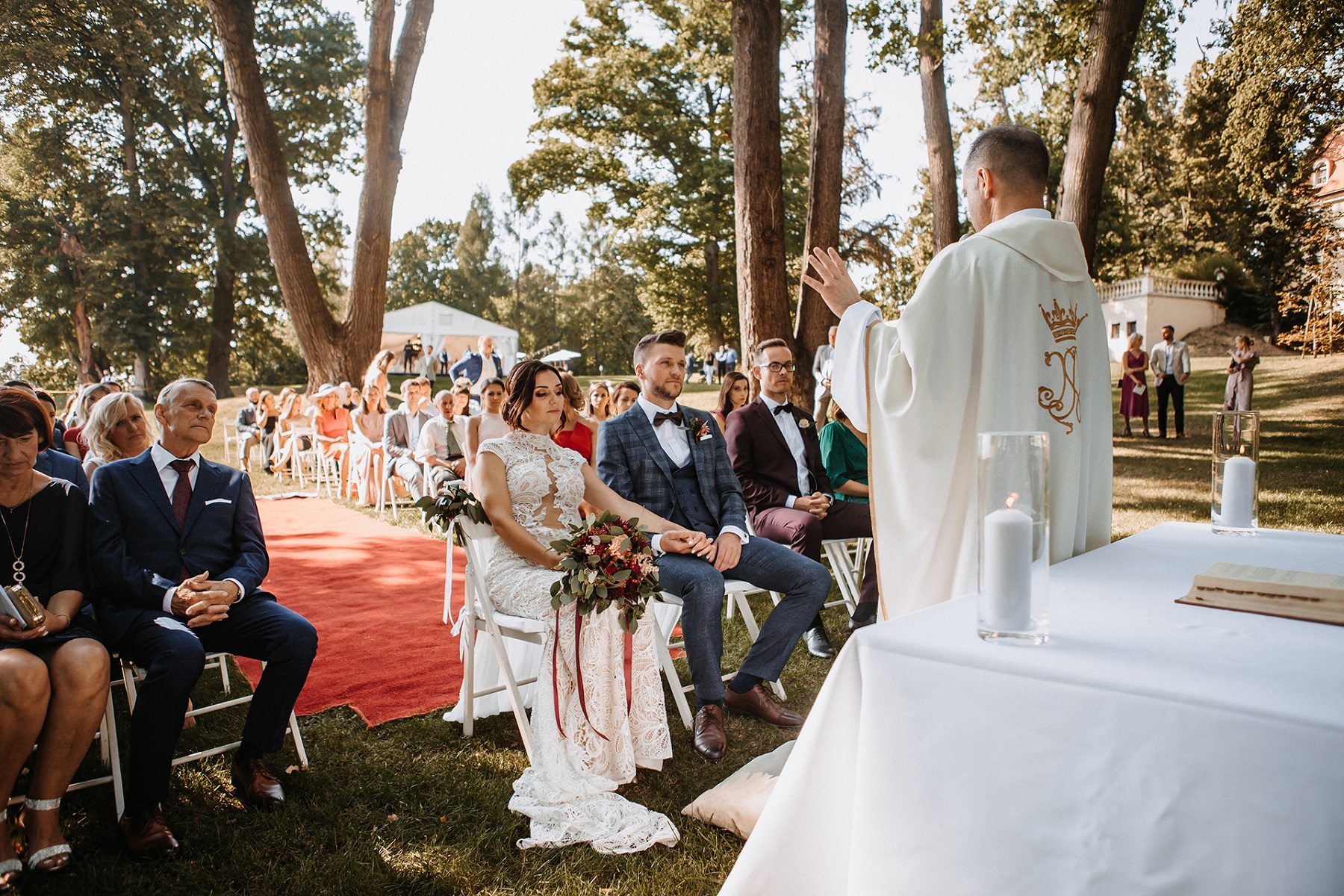 ślub kościelny w plenerze w ogrodzie czerwony dywan