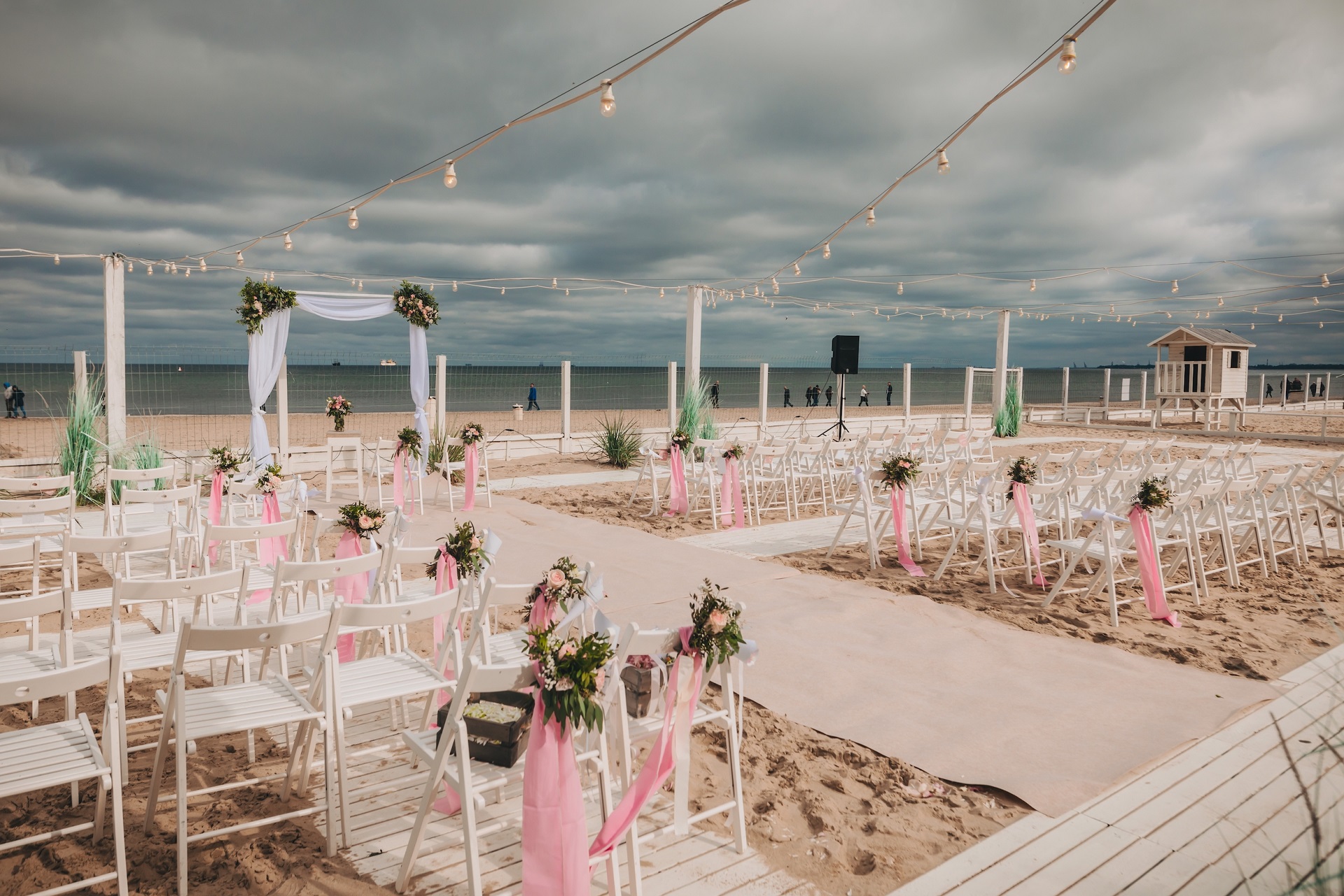 ślub plenerowy na plaży dekoracje, girlandy świetlne i krzesła