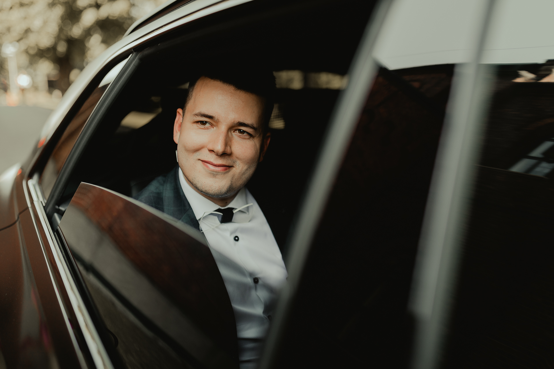 elegancki pan młody w samochodzie fotografia ślubna reportaż ślubny 