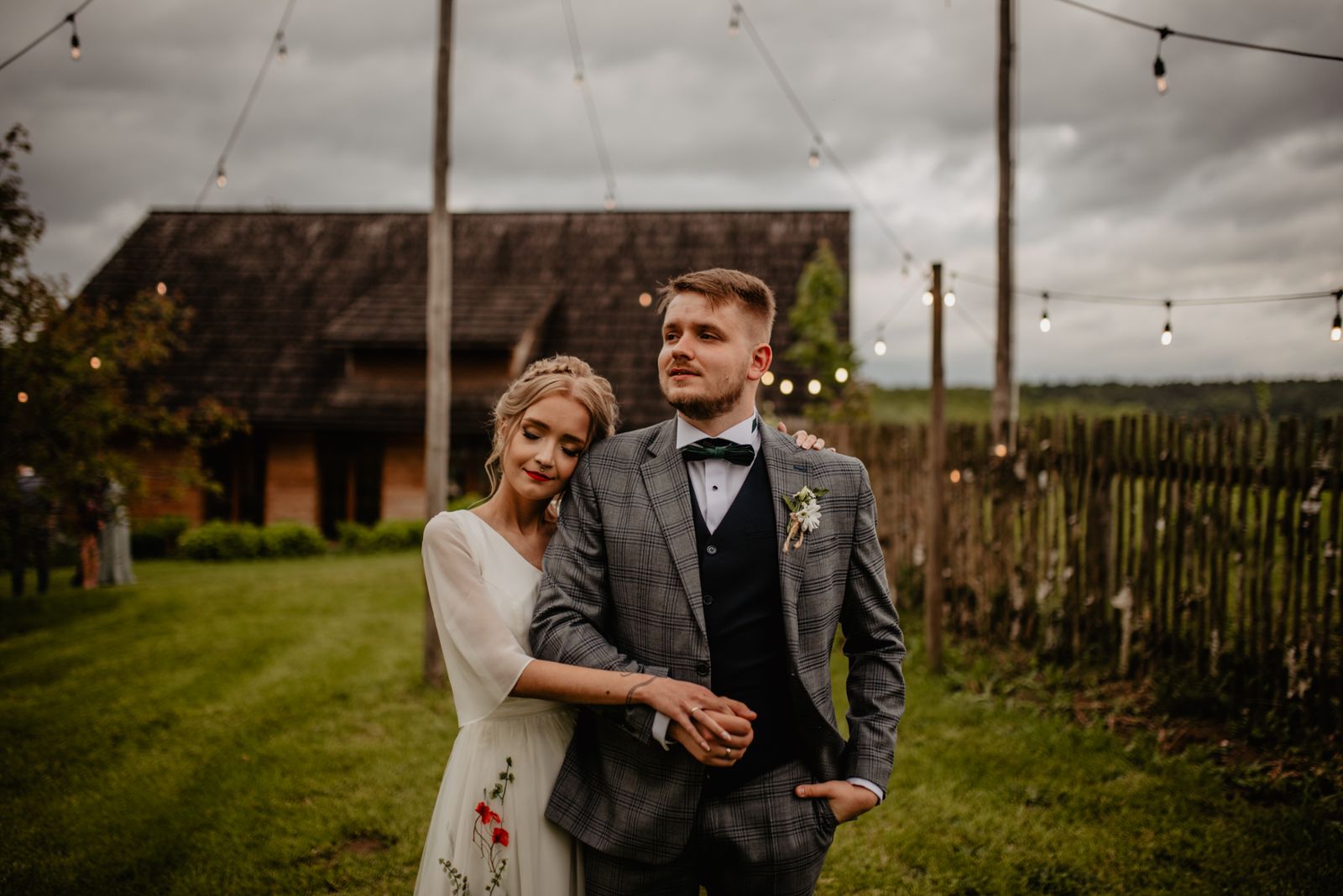 sesja ślubna przed salą Panna Młoda w sukni ślubnej w kwiaty, Pan Młody w garniturze w kratę