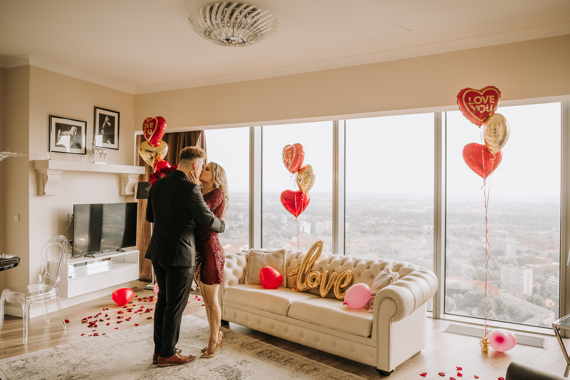 zaręczyny niespodzianka w eleganckim apartamencie całująca się para napis love złoty dekoracje sesja narzeczeńska